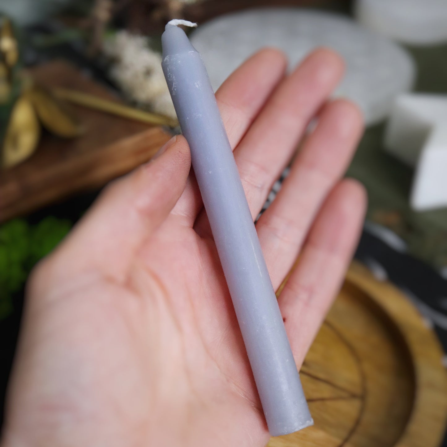 Bougie de sorcellerie de couleur grise posé dans une main
